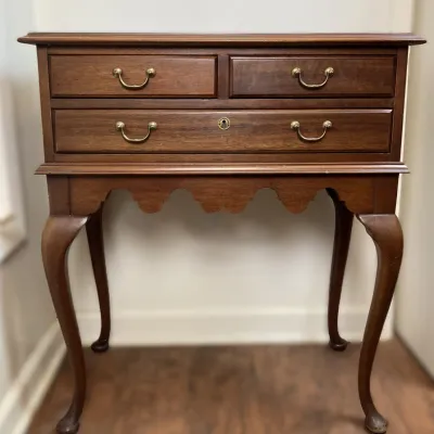 Sale Photo Thumbnail #28: Queen Anne style mahogany server or side table featuring three drawers with brass bail pulls, a scalloped apron, and slender cabriole legs.