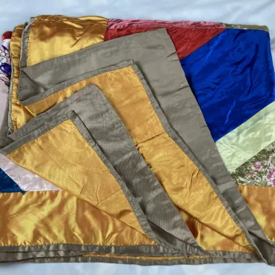 Sale Photo Thumbnail #103: Vintage handmade crazy quilt featuring colorful silk, satin, and velvet patchwork panels with a grey-brown border.