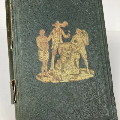 Sale Photo Thumbnail #93: Antique hardbound book in dark green cloth featuring gilt pictorial cover embossing depicting an auction scene. Shows significant wear along the spine including tears and edge frayed binding.