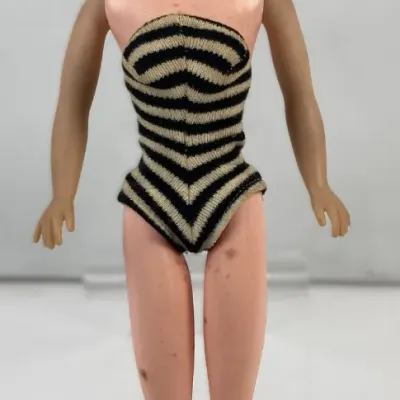 Sale Photo Thumbnail #110: Vintage #1 or #3 ponytail Barbie doll wearing a black and white zebra swimsuit and pearl earrings, displaying some light age discoloration.