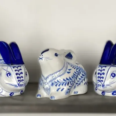 Sale Photo Thumbnail #76: Collection of five blue and white ceramic rabbit figurines and covered dishes displayed on a shelf.