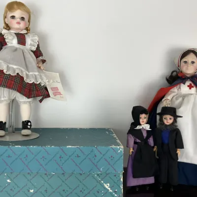 Sale Photo Thumbnail #125: Collection of vintage Madame Alexander collectible dolls, including a Mary Ann doll in a red plaid dress with original tag, a Red Cross nurse, and two smaller traditional figures.