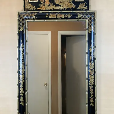 Sale Photo Thumbnail #130: Vintage Chinoiserie wall mirror featuring a gilt faux-bamboo frame with a black hand-painted landscape crest and floral motif accents.