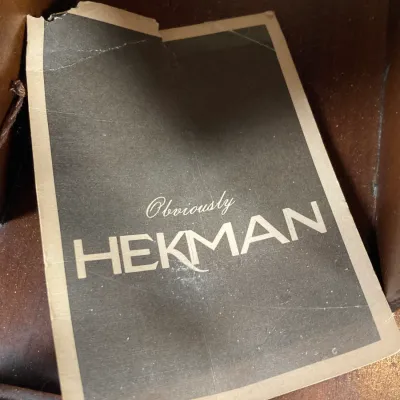 Sale Photo Thumbnail #61: Vintage "Obviously HEKMAN" paper manufacturer tag attached to a piece of furniture, showing wear and tear.