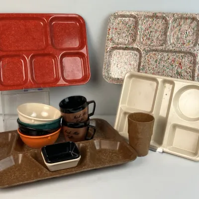 Sale Photo Thumbnail #24: Collection of vintage cafeteria-style melamine compartment trays, stacked plastic bowls, brown 'Irish Mist Coffee' mugs, and a tumbler.