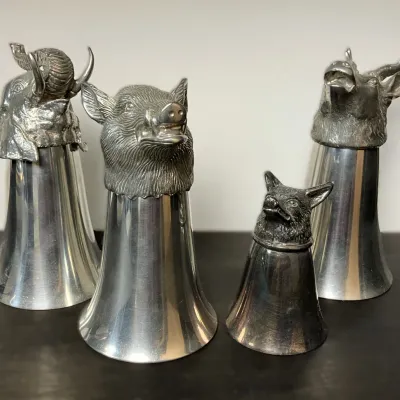 Sale Photo Thumbnail #63: Set of four vintage metal stirrup cups featuring detailed animal head bases, including an elephant, boar, fox, and stag.