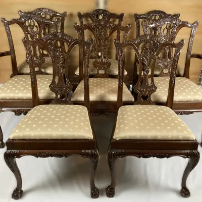 Sale Photo Thumbnail #86: Set of eight Chippendale style carved mahogany dining chairs, including two armchairs and six side chairs with upholstered seats and ball-and-claw feet.