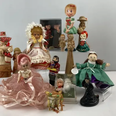 Sale Photo Thumbnail #195: Eclectic collection of vintage dolls and figurines, including a Madame Alexander doll in lace attire, corn husk dolls, and novelty bobbleheads.