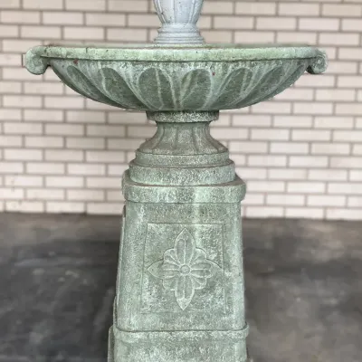 Sale Photo Thumbnail #235: Tiered stone garden fountain featuring a classical pedestal base with floral relief carvings and a scuted water basin, showing weathered patina.