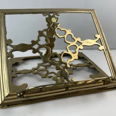Sale Photo Thumbnail #101: Vintage brass tabletop book stand featuring cutout heart scrollwork and an adjustable easel back.