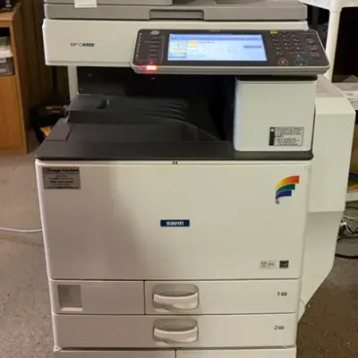Savin MP C4502 commercial multi-function office printer and copier featuring a digital touchscreen interface, automatic document feeder,...
