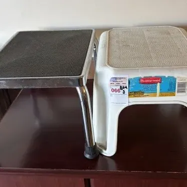 Pair of small step stools, including a chrome frame stool with a black textured rubber top and a white plastic Rubbermaid step stool.