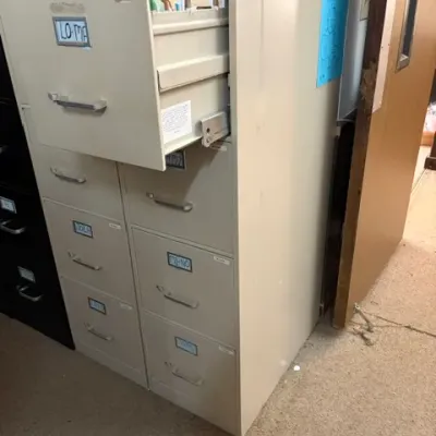 Beige vintage metal filing cabinets with multiple drawers, 
