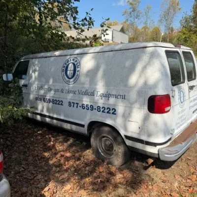 White Dodge Ram Van commercial delivery vehicle featuring 'Oxygen Plus Medical Equipment' signage on the side, showing exterior...