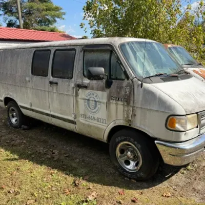 White Dodge Ram 250 cargo van with Oxygen Plus branding, showing heavy exterior wear, dirt, and weathering.