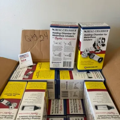 Cardboard box packed with multiple new-in-box Medquip Airial Chamber holding chambers for meter-dose inhalers with Spotz pediatric masks.