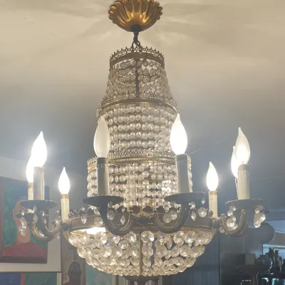 Sale Photo Thumbnail #160: Vintage French Empire style brass and crystal chandelier featuring a tiered beaded waterfall design with multiple candle-style lights.