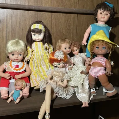 Sale Photo Thumbnail #54: Collection of vintage 1960s and 1970s vinyl and poseable dolls displayed on a shelf, showing varying degrees of wear.
