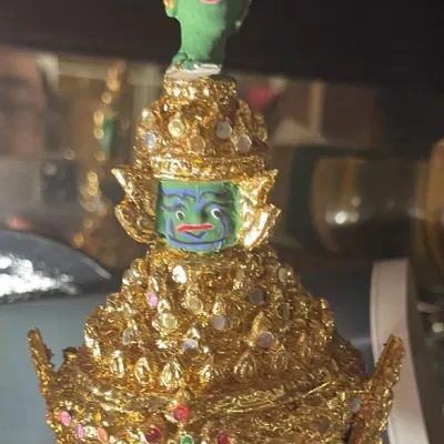 Sale Photo Thumbnail #189: Miniature Thai Khon dance mask featuring ornate gold foil trim, colorful jewel accents, and painted green demon face details.