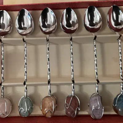 Sale Photo Thumbnail #95: Set of six vintage silver-tone demitasse spoons featuring twisted stems and wire-wrapped polished gemstone finials, stored in their original display box.