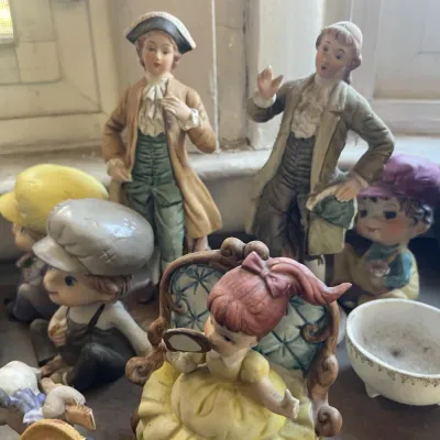 Sale Photo Thumbnail #168: Collection of vintage porcelain and ceramic figurines, including 18th-century style courtly figures and whimsical children characters.