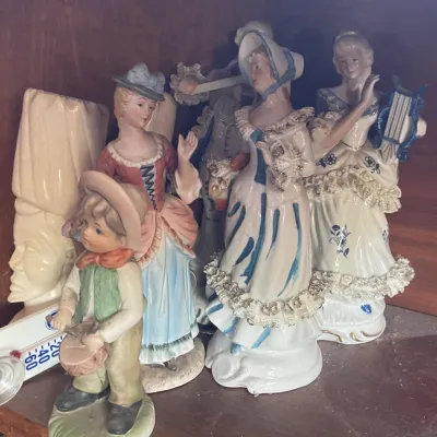 Sale Photo Thumbnail #165: Collection of vintage porcelain figurines depicting 18th-century courtly figures and children, featuring hand-painted lace details and musical instruments.