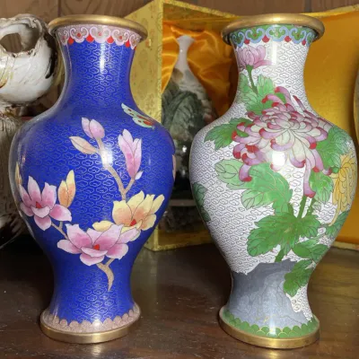 Sale Photo Thumbnail #128: Pair of Chinese cloisonné brass vases featuring intricate floral motifs over cobalt blue and white patterned grounds.