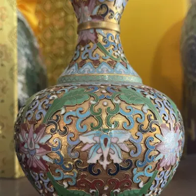 Sale Photo Thumbnail #188: Intricately detailed Chinese cloisonné enamel vase featuring floral and scroll motifs over a gilded brass ground.