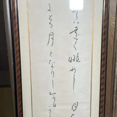 Sale Photo Thumbnail #73: Framed Asian calligraphy art piece featuring vertical script on a light mat with a dark wooden frame.