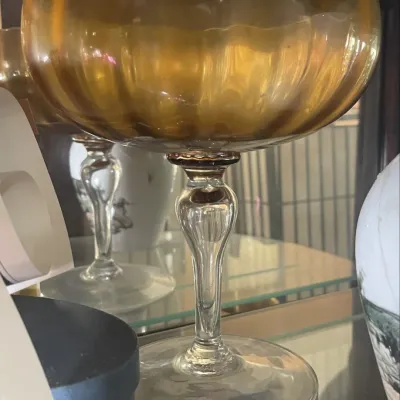 Sale Photo Thumbnail #192: Vintage amber glass stemmed goblet featuring a ribbed bowl and a clear, elegant stem.