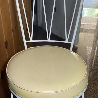 Sale Photo Thumbnail #52: Mid-century modern wrought iron chair featuring a white painted frame with a diamond-patterned backrest, hairpin legs, and a cream vinyl cushioned seat.