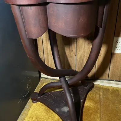 Sale Photo Thumbnail #47: Vintage dark stain wooden accent table featuring a scalloped clover-leaf shaped top and a curved, interlocking leg base. Shows light wear and dust to the top finish.