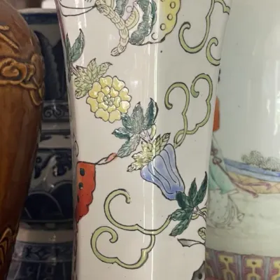 Sale Photo Thumbnail #167: Tall vintage hexagonal ceramic vase featuring hand-painted botanical motifs and butterflies in soft pastel enamels.