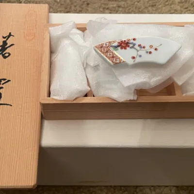 Sale Photo Thumbnail #81: Set of Japanese porcelain chopstick rests by Fukagawa, featuring hand-painted fan motifs and presented in the original fitted wooden tomobako box.