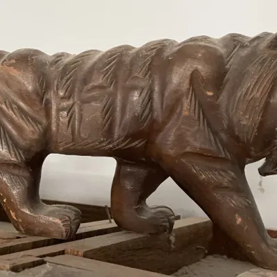 Sale Photo Thumbnail #117: Hand-carved wooden tiger figurine with visible carved texture and a rich dark finish, showing slight surface wear consistent with age.
