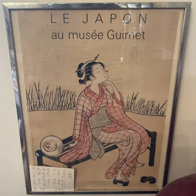 Sale Photo Thumbnail #150: Framed vintage exhibition poster for 'Le Japon au musée Guimet', depicting a seated Japanese woman in a kimono, set within a chrome frame.