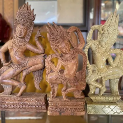 Sale Photo Thumbnail #3: Trio of hand-carved Southeast Asian Apsara dancer figurines, featuring detailed crowns, traditional poses, and intricate relief bases.