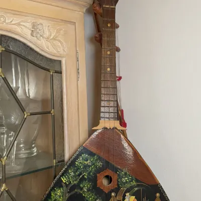 Sale Photo Thumbnail #74: Hand-painted traditional Russian balalaika string instrument, featuring a detailed lacquer-style fairytale scene on the wooden body.
