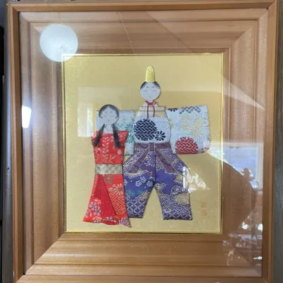 Sale Photo Thumbnail #69: Framed Japanese fabric collage art depicting Hinamatsuri dolls made with brocade silk textiles, set against a gold mat in a deep wooden frame.
