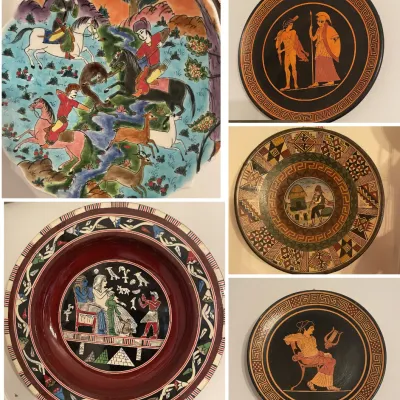 Sale Photo Thumbnail #199: Collection of decorative wall plates featuring Persian miniature, ancient Greek black-figure style, Egyptian revial, and geometric folk art motifs.
