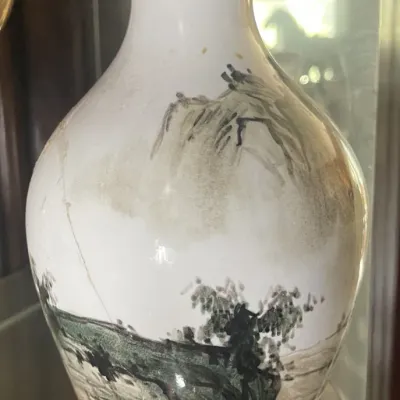 Sale Photo Thumbnail #191: Asian-style ceramic vase featuring a hand-painted landscape scene with mountains and trees in muted tones.