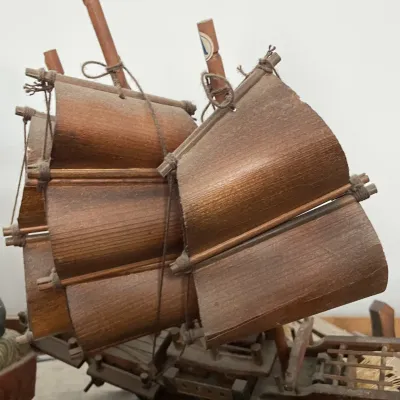 Sale Photo Thumbnail #115: Handcrafted vintage wooden junk boat model featuring detailed wood veneer sails and bamboo masts, showing minor dust and age-appropriate wear.