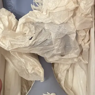 Sale Photo Thumbnail #94: Wedgwood blue jasperware decanter or bottle vase featuring white bas-relief cherub motifs, nestled in tissue paper inside its original box.