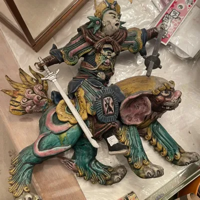 Sale Photo Thumbnail #139: Intricately detailed Chinese Shiwan glazed ceramic figure depicting a warrior holding swords while riding a mythical lion beast.