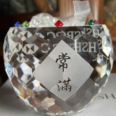 Sale Photo Thumbnail #124: HSBC Bank Faceted crystal feng shui treasure bowl featuring frosted diamond panel with Chinese characters, filled with small clear and colorful synthetic gemstones.