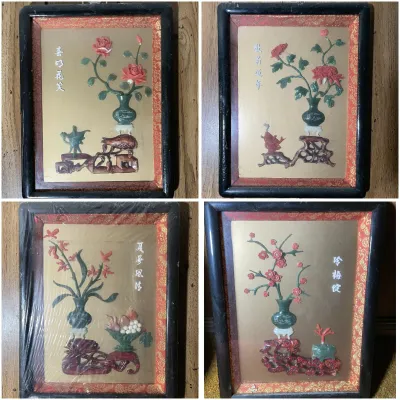 Sale Photo Thumbnail #205: Set of four vintage Chinese carved jade and soapstone relief wall plaques, each depicting floral still-life arrangements in black frames with red brocade borders.
