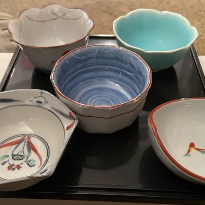 Sale Photo Thumbnail #83: Set of five vintage Japanese Koransha porcelain sauce bowls, each featuring a unique hand-painted design and shape on a black tray.
