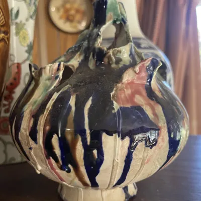 Sale Photo Thumbnail #164: Handcrafted studio pottery vase featuring a bulbous body with abstract dripped glazes in cobalt blue, pink, green, and brown.
