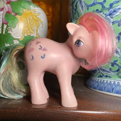 Sale Photo Thumbnail #130: Vintage 1980s Hasbro My Little Pony G1 figure in pink with rainbow hair, displaying minor wear.