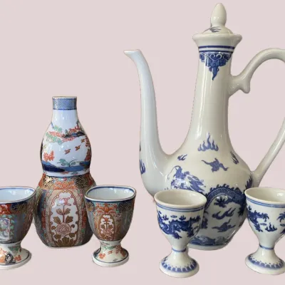 Sale Photo Thumbnail #11: Collection of Asian porcelain sake and wine sets, including a blue-and-white dragon pot with matching cups and an Imari-style gourd decanter set.